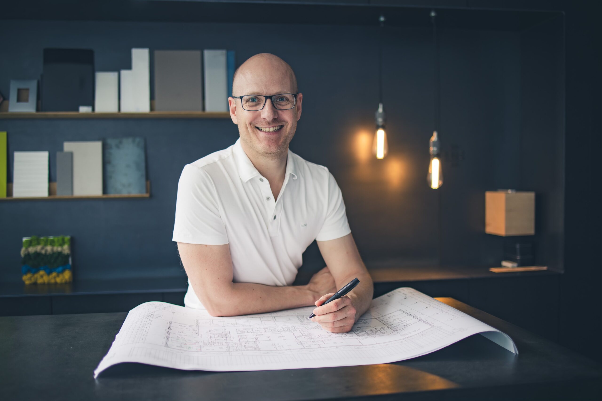 Florian Schafhäutl mit Grundrissen Der Inhaber von roomanddesign, Florian Schafhäutl, arbeitet an einem Grundriss
